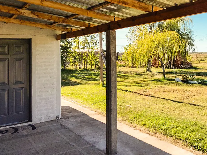Galería exterior del hospedaje "Rincón Verde", en Luis Beltrán, Río Negro.